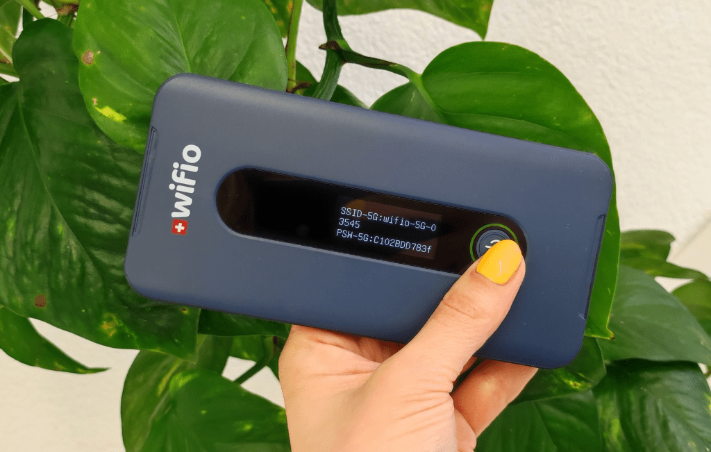 Person holding Wifio pocket WiFi device for easy setup in Switzerland – quick connection for travelers
